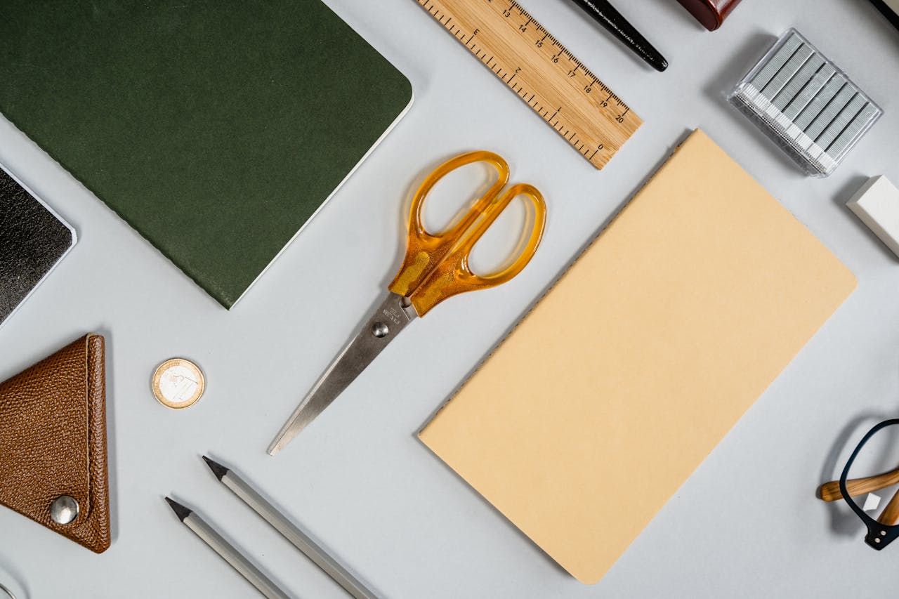 services-02 Flat lay showcasing various office supplies including scissors, notebook, ruler, and pencil.